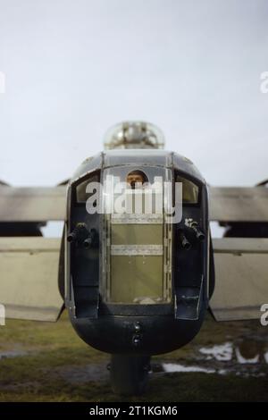 The rear gunner of a Lancaster of No. 44 Squadron peeks out through a cut-out in the perspex of his gun turret, October 1942. A gunner, believed to be Sergeant J Bell, looks through the opening in the perspex of the rear turret of Avro Lancaster R5740/`KM-O'. The four guns shown are Browning .303 machine guns. Stock Photo